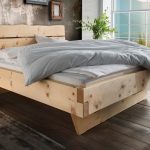Zirbenholzbett Kitzbühel in einem Schlafzimmer mit Holzfußboden