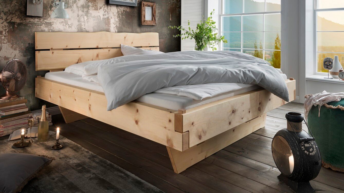 Zirbenholzbett Kitzbühel in einem Schlafzimmer mit Holzfußboden